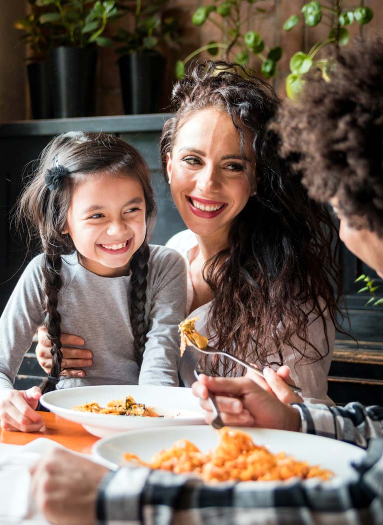Smiling woman and child eating a nutritious meal with Wild Planet Foods ingredients